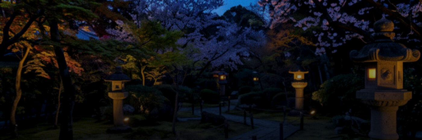 A Japanese garden at dusk, stone lanterns lit